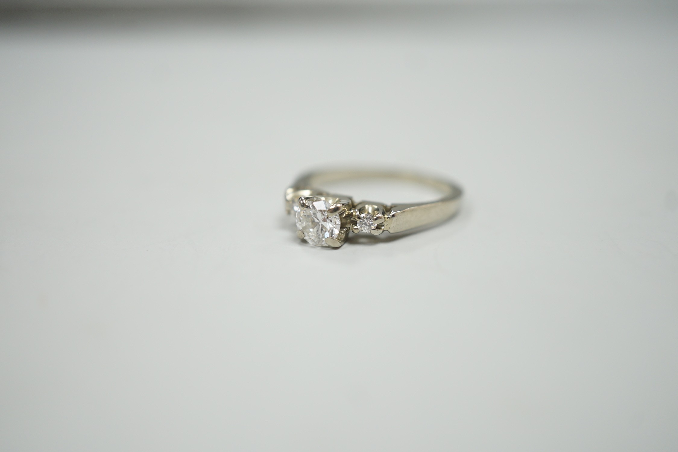 A Canadian Birks 18k white metal and single stone diamond ring, with diamond set shoulders, size H, gross weight 2.7 grams